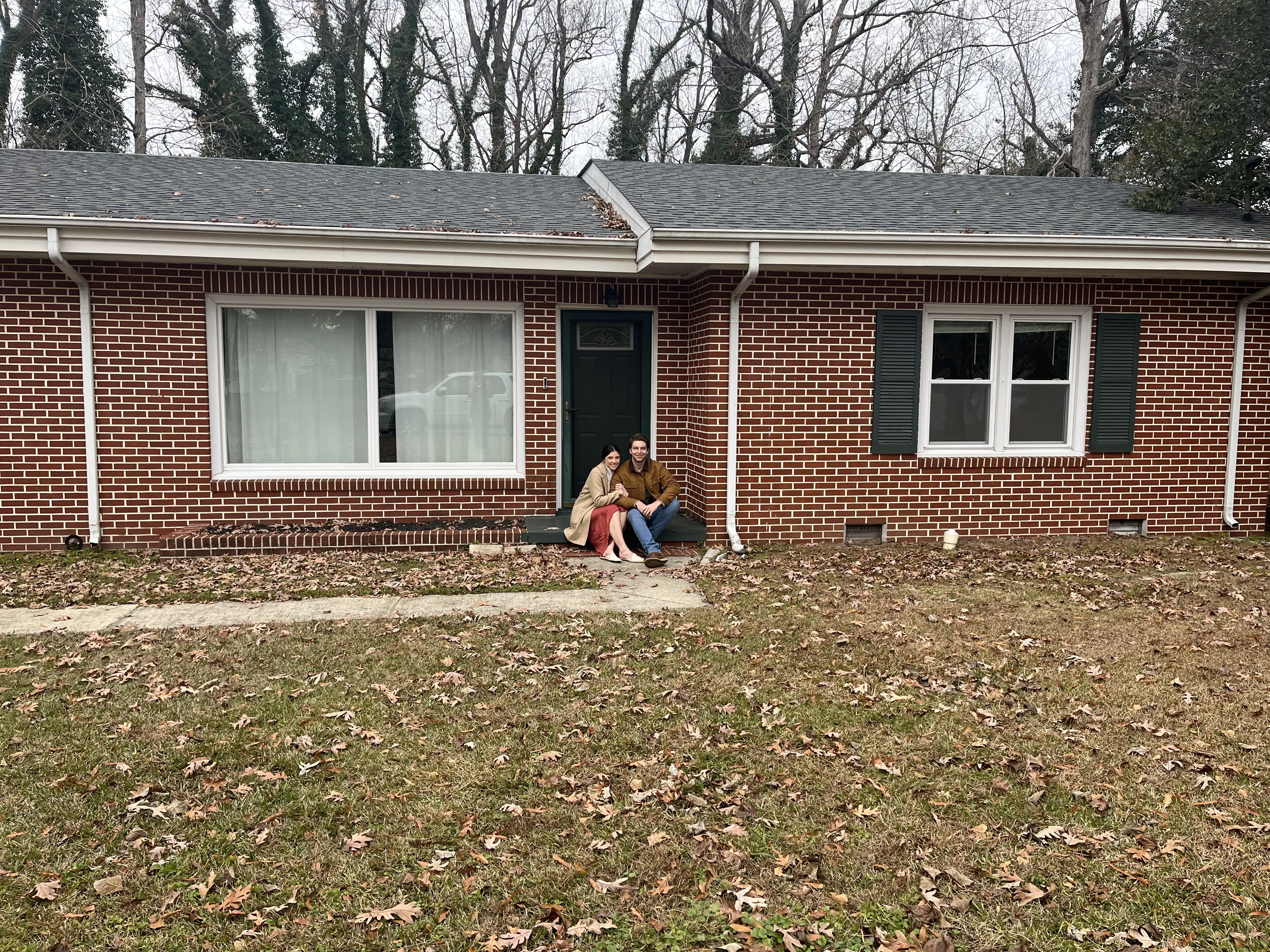 holden and martie sitting on front porch of the new house we just bought